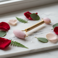 Glow Ice Roller for face and neck on marble surface with rose petals